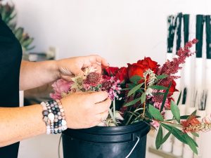 arranging flowers in bucket